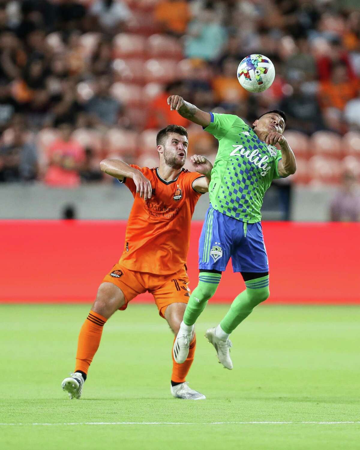 Seattle Sounders forward Raúl Ruidíaz (9) uses his shulder to control the ball against Houston Dynamo FC defender Ethan Bartlow (13) during the first half of an MLS match at PNC Stadium on Wednesday, May 18, 2022, in Houston.
