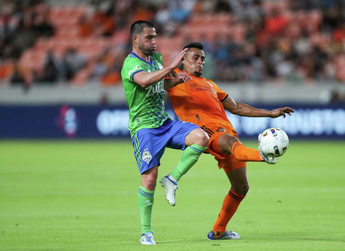 Houston Dynamo FC midfielder Darwin Cerén (24) and Seattle Sounders midfielder Nicolás Lodeiro (10) battle for possession of the ball during the first half of an MLS match at PNC Stadium on Wednesday, May 18, 2022, in Houston.