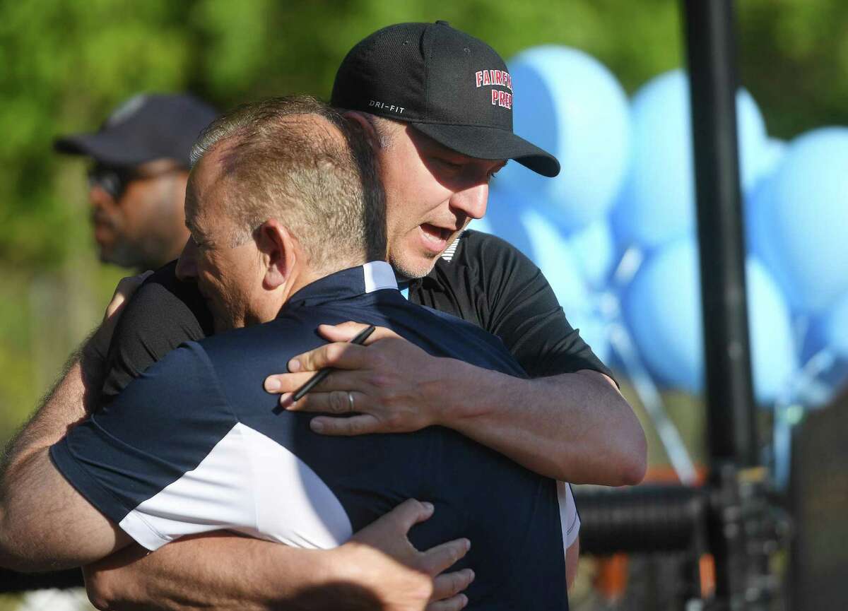 Fairfield Prep lacrosse Coach Graham Niemi receives hugs of support after the death of player James McGrath, before the Prep-Shelton lacrosse game at Shelton High School in Shelton, Conn. on Wednesday, May 18, 2022.