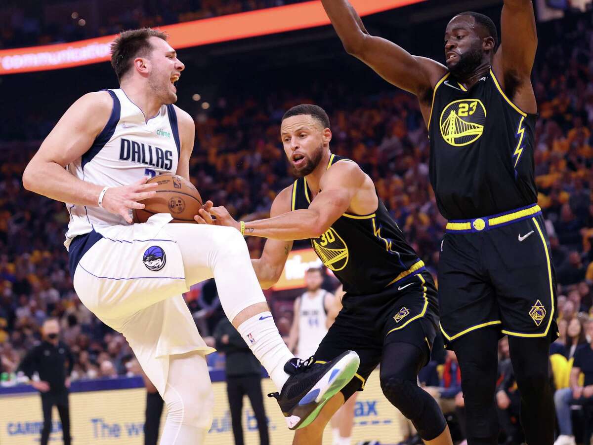 Golden State Warriors’ Stephen Curry and Draymond Green guard Dallas Mavericks’ Luka Doncic in 1st quarter of Game 1 of NBA Western Conference Finals at Chase Center in San Francisco, Calif., on Wednesday, May 18, 2022.