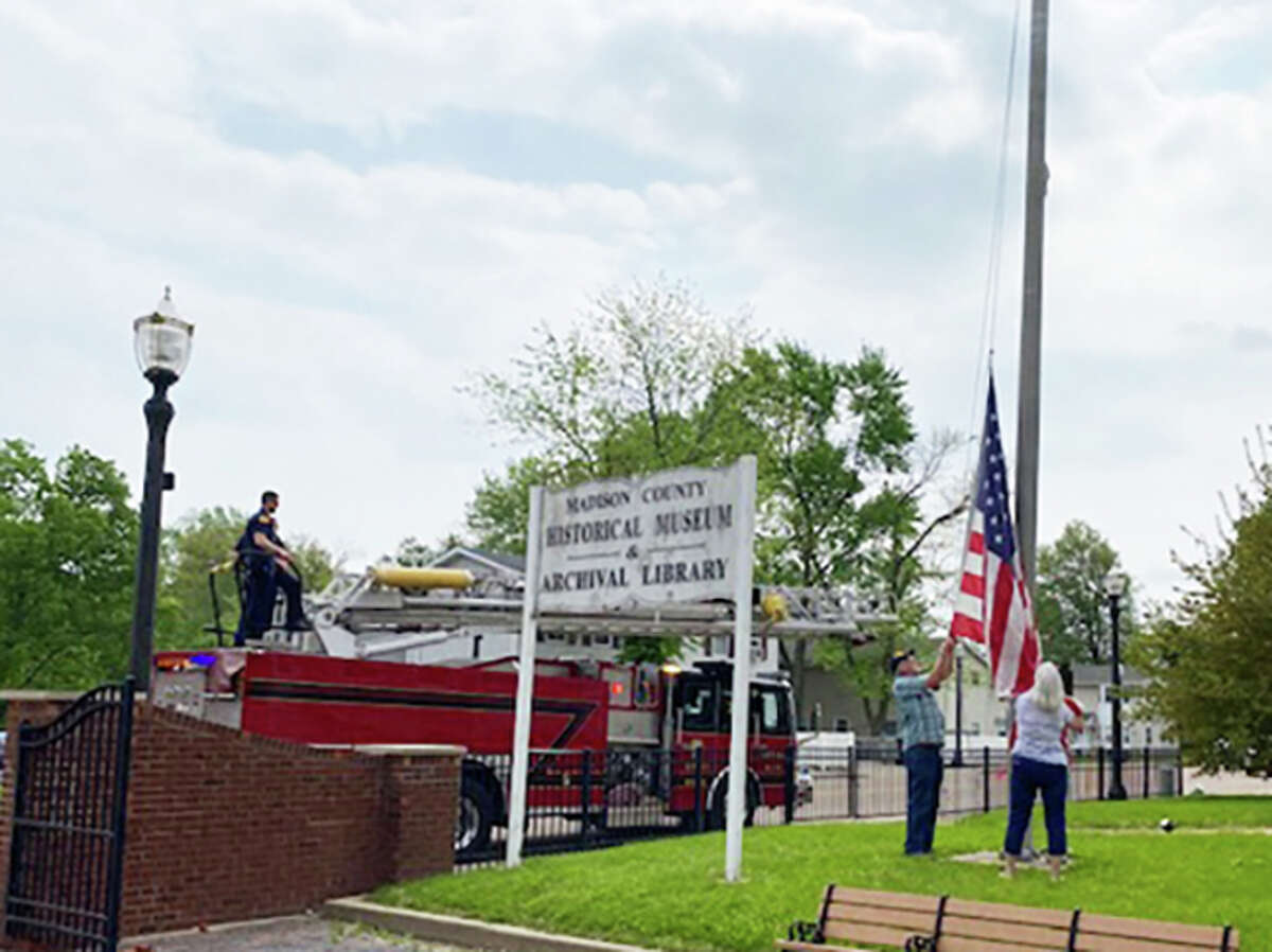Woody and Kathie Daugherty, right, remove a damaged American flag at the Madison County Historical Society Museum and Archival Library in Edwardsville with help from the Edwardsville Fire Department. The flag had been caught on a chain on a flagpole.