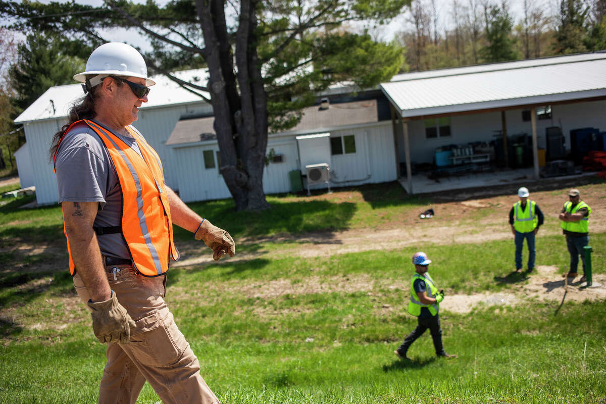 Four Lakes Task Force Operators Joe Rybkowski, left, and Brandon Heath, center, walk along the embankment doing a visual inspection Thursday, May 12, 2022 at the Four Lakes Task Force Dam Offices in Beaverton.