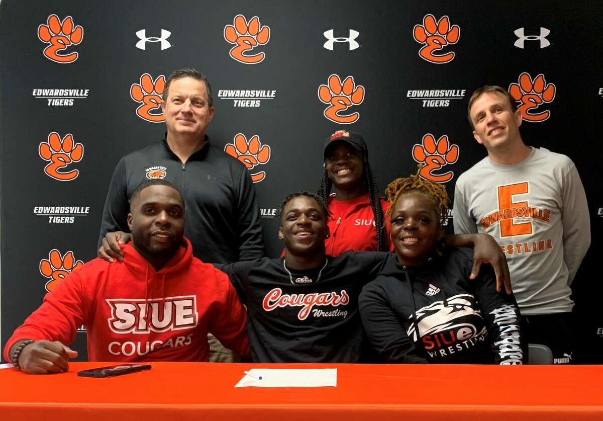 Edwardsville High School senior Jorden Johnson, seated center, will wrestle for SIUE. He is joined by family and EHS coaches.