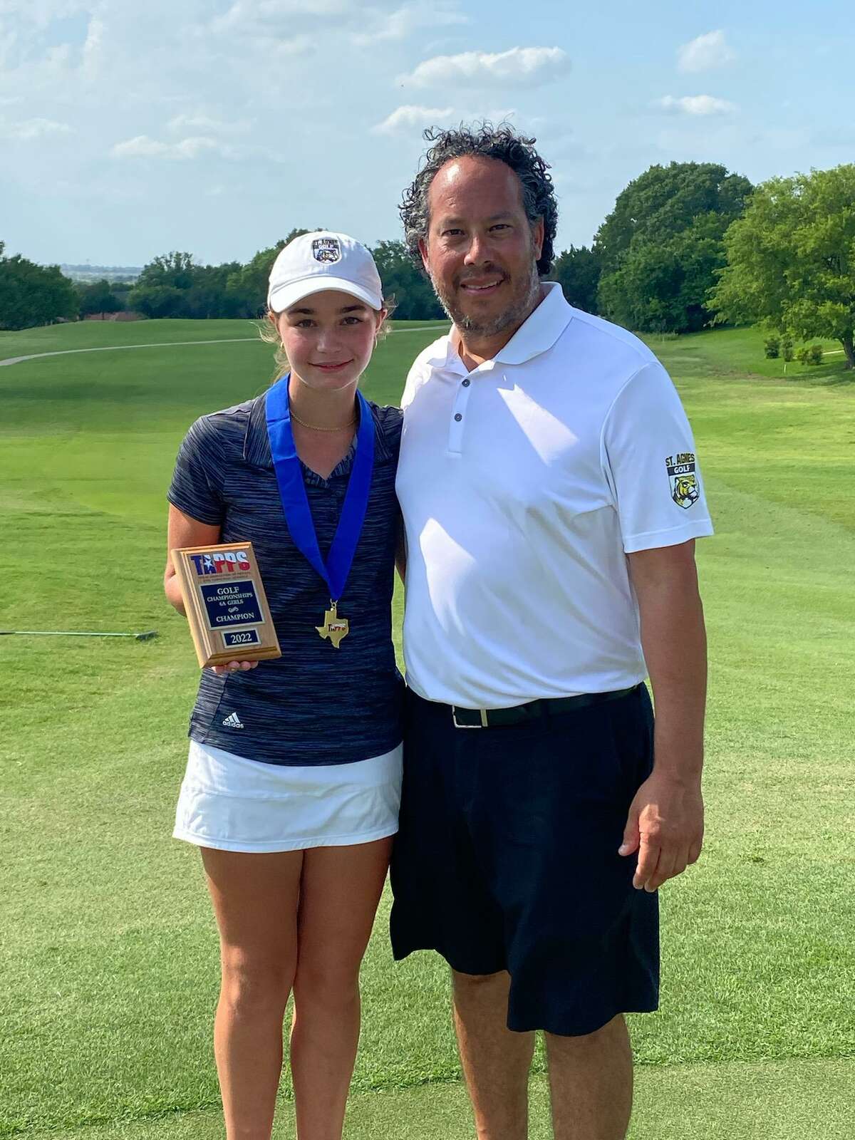St. Agnes Academy freshman Sophia Ellestad poses with head golf coach Louis Mexia after winning the individual championship at the TAPPS 6A state tournament on May 9 and 10 at Wildflower Country Club in Temple
