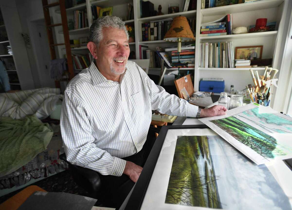 George Wiles looks out over the Housatonic River marshes from his art studio in his home on Milford Point Road in Milford, Conn. Wednesday, May 18, 2022. Wiles and wife Arla are hosting a fundraiser for the Norma F. Pfriem Breast Care Center featuring Wiles' watercolor paintings as both raffle and silent auction items.