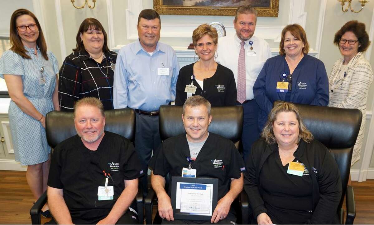 Greg Lorsbach, seated in the middle holding his plaque, received his honor as the 2021 Alton Memorial Hospital Employee of the Year on May 9. Presenting the award were, on either side of Greg, his Human Motion Institute co-workers Scott Allsman and Beth Eldridge; back row left to right, Chief Medical Officer Dr. Laura Barton, Chief Nursing Officer Debbie Turpin, President Dave Braasch, HMI Manager Sue Walker, Chief Operating Officer Brad Goacher, Director of Patient Care Cindy Bray, and BJC Group President Joan Magruder.