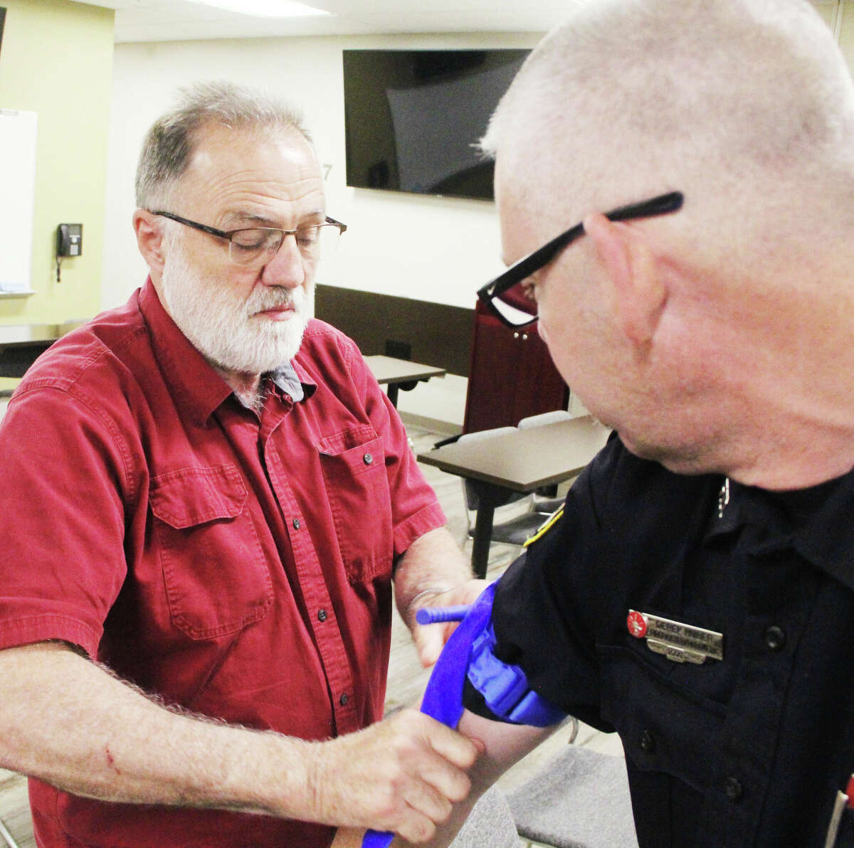 Jeff Graser, left, of Wood River, practices putting a tourniquet on Edwardsville Firefighter/Paramedic Derek Huber during a "Stop the Bleed" class Thursday at the Edwardsville Public Safety Building. May is "Stop the Bleed Month." The program is designed to teach people how to deal with excessive bleeding, which is a major cause of preventable death.