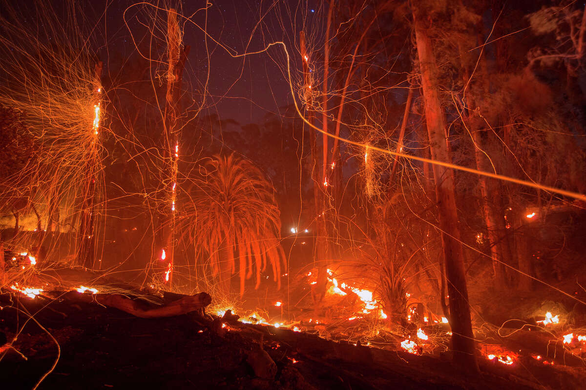 A strong wind blows embers from smoldering trees at the Thomas Fire on Dec. 16, 2017, in Montecito. The fire later ushered in mudslides that winter that killed 23 in the town. Today, homeowners in the ultra-wealthy enclave have a difficult time insuring their properties. 