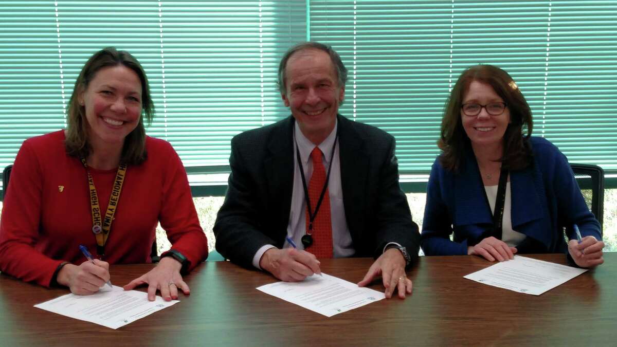 Principals of Amity Regional School District No. 5, Woodbridge, sign letters for their schools to become part of the state’s Green Leaf program. From left, Anna Mahon, Amity Regional High School, Woodbridge; Richard Dellinger, Amity Middle School, Bethany, and Kathy Burke, Amity Middle School, Orange. The free program of the departments of Education, Energy and Environmental Protection, Administrative Services, and Public Health, with three dozen environmental and educational partners, aims to help schools to grow greener.