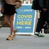 People walk past a Covid testing site on May 17, 2022, in New York City. New York’s health commissioner, Dr. Ashwin Vasan, has moved from a "medium" COVID-19 alert level to a "high" alert level in all the five boroughs following a surge in cases. (Spencer Platt/Getty Images/TNS)