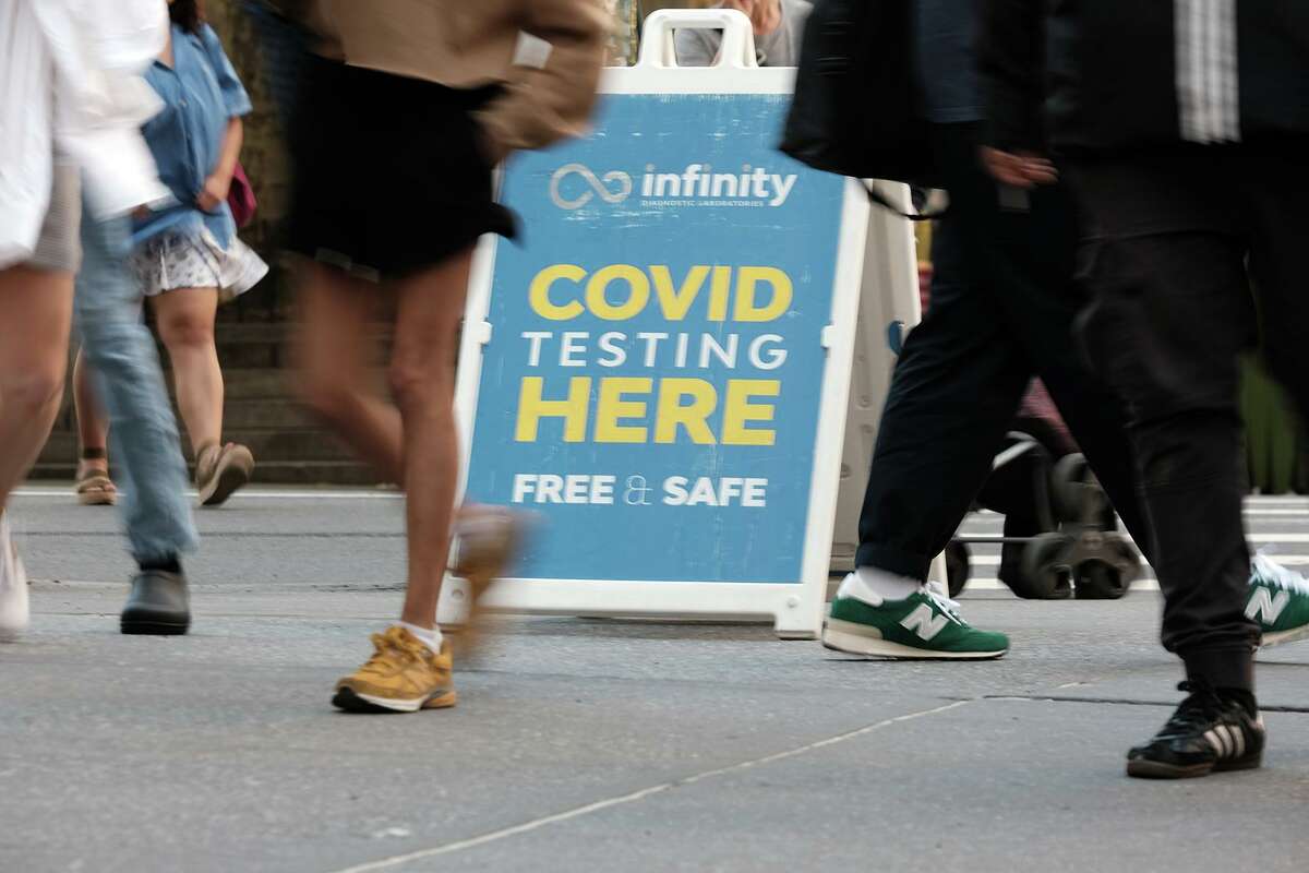 People walk past a COVID testing site on Tuesday in New York City. Connecticut finds itself amid a COVID-19 wave, but experts think Connecticut’s current outbreak might be nearing its peak.