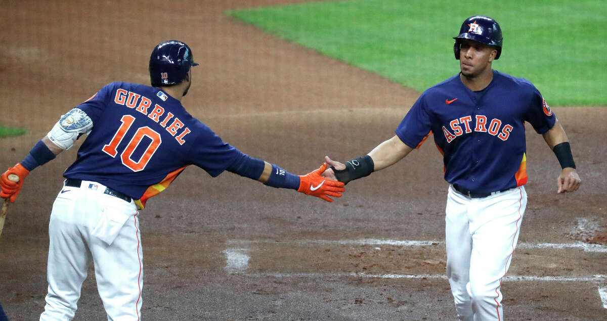 Houston Astros Michael Brantley (23) celebrates his run scored with Yuli Gurriel (10) on Alex Bregman's RBI single during the first inning of an MLB baseball game at Minute Maid Park, Sunday, May 16, 2021, in Houston.