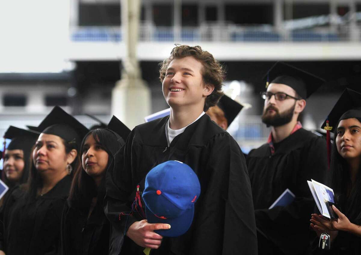 Graduate Van Thompsen holds his New York Mets cap over his heart during the singing of the National Anthem at the Norwalk Community College 60th annual Commencement Exercises at the Hartford HealthCare Amphitheater in Bridgeport on Thursday.