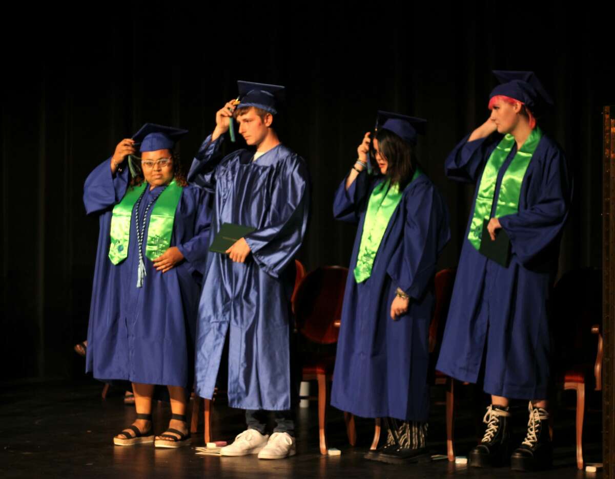 CASMAN Academy graduates Daydreana Davis (left), Ethan Raymond, Kyli Stoudt and Jada Terryn move their tassels from right to left Thursday during a commencement ceremony at the Ramsdell Theatre in Manistee.