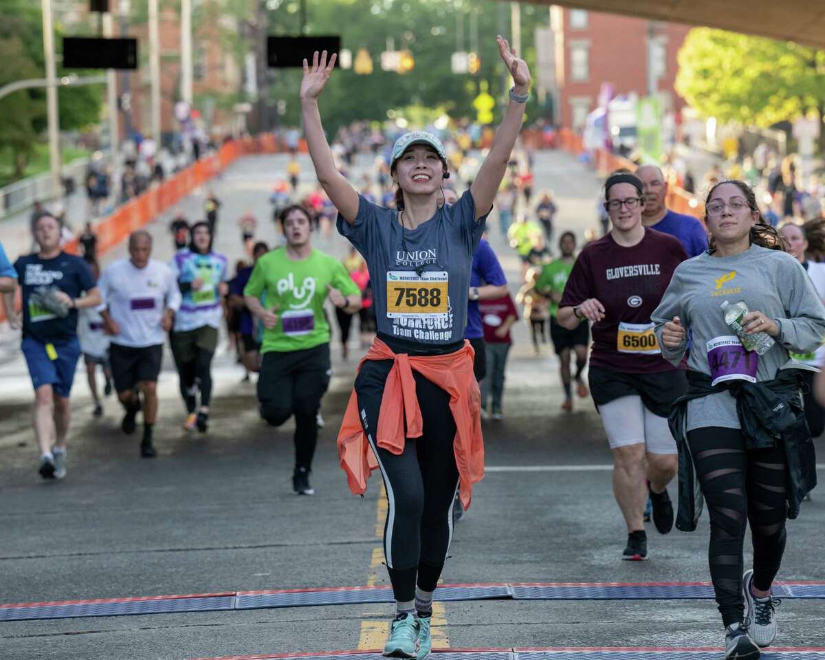 Alicia Dang, of the Union College team, raises her arms after crossing the finish line of the CDPHP Workforce Challenge race on Madison Avenue in Albany, NY, on Thursday, May 19, 2022. (Jim Franco/Special to the Times Union)