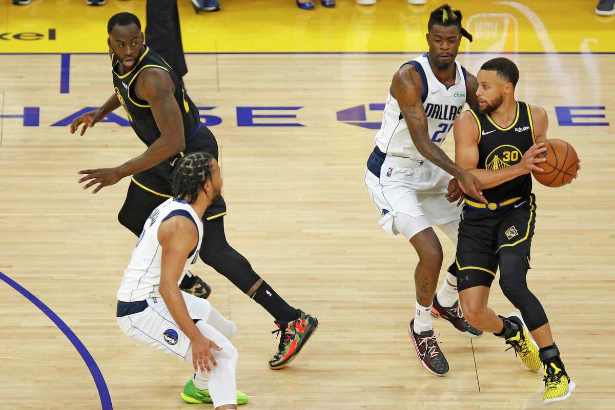 Golden State Warriors guard Stephen Curry (30) looks to pass against Dallas Mavericks forward Reggie Bullock (25) in the first quarter of Game 1 of the NBA Western Conference finals at Chase Center, Wednesday, May 18, 2022, in San Francisco, Calif.