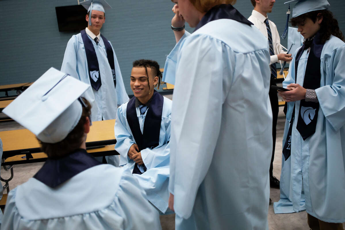 Deante Shaw, center, chats with friends as the Meridian Early College High School Class of 2022 celebrate their commencement Thursday, May 19, 2022 at the school in Sanford.