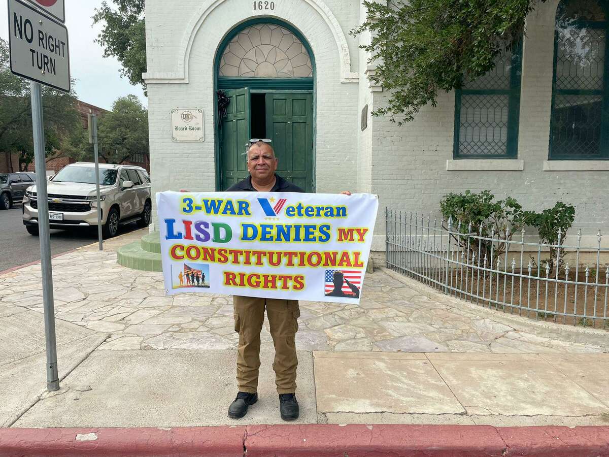Jorge Martínez, a war veteran and now an instructor at Martin High School, holds a banner expressing his disagreement.