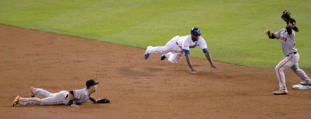 Giants Brandon Crawford catches a flipped ball from Giants Joe Panik to start a double play during Game 7 of the World Series at Kauffman Stadium on Wednesday, Oct. 29, 2014 in Kansas City, Mo.