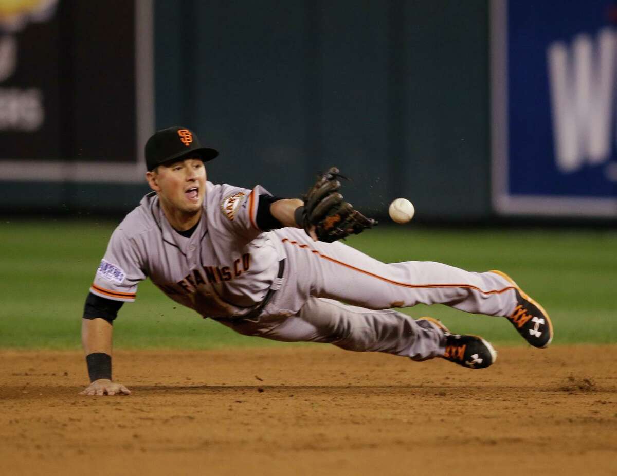 Second baseman Joe Panik flips the ball to shortstop Brandon Crawford to start a third-inning double play during the Giants’ Game 7 victory over the Royals in the 2014 World Series.