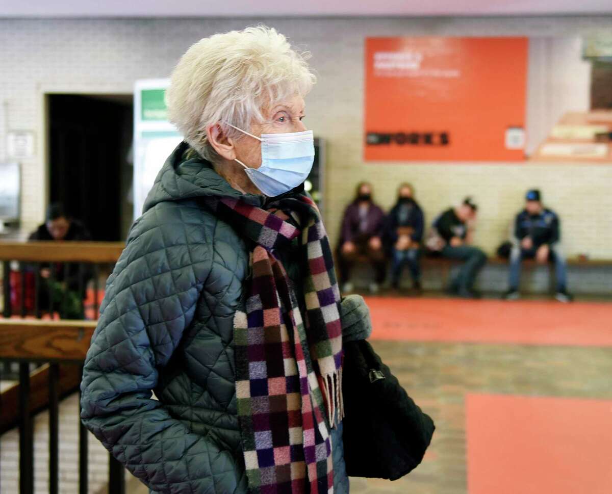 Greenwich's Rhoda Pappenheimer wears a mask while waiting for her train inside the Greenwich Metro-North station in Greenwich, Conn.