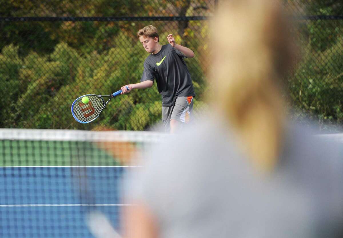 Residents play tennis on one of Dickinson Park’s courts in Newtown, Conn.