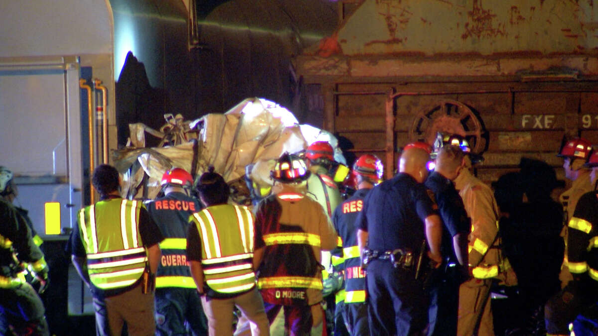 Emergency personnel work to clear wreckage after a truck crashed into a parked train just after 2 a.m. Friday, on the West Side near U.S. 90. Shortly after, a second train then crashed into the truck, wedging it between the two trains. The driver and passenger were able to get out of the vehicle and no injuries were reported. 