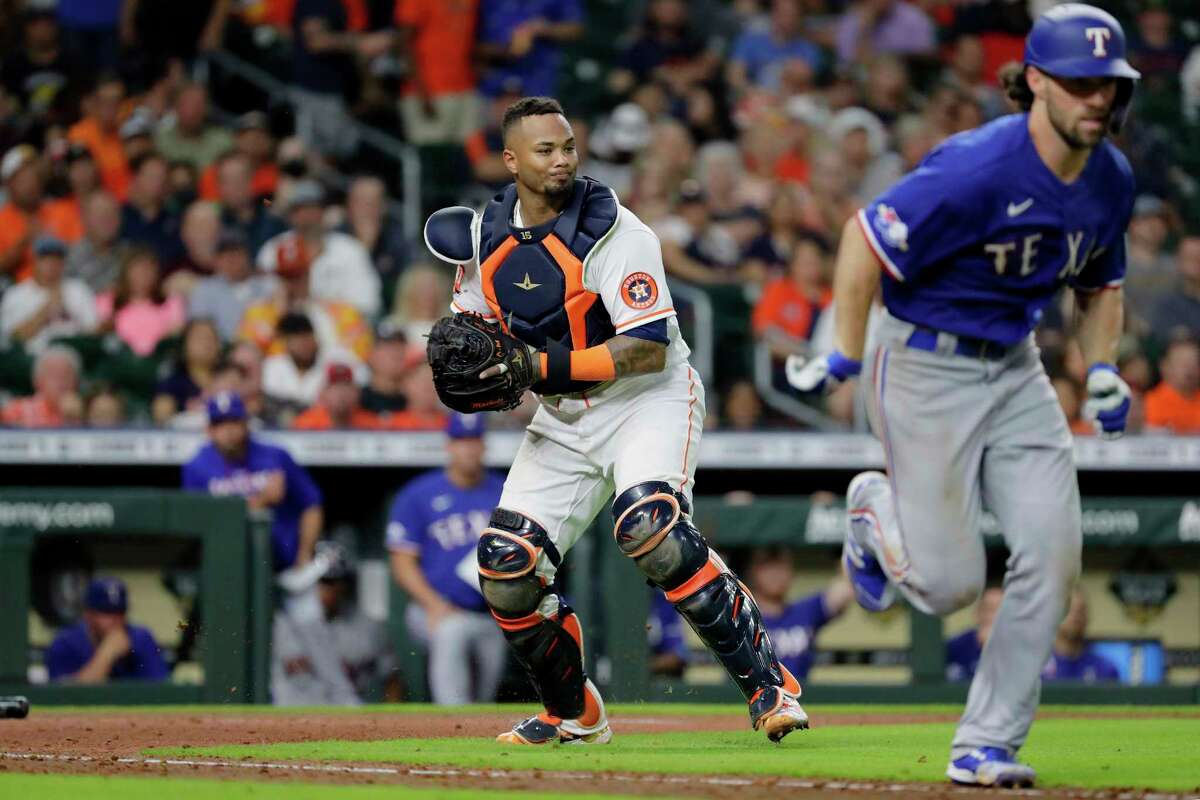 Houston Astros catcher Martin Maldonado, left, prepares to throw to first on a sacrifice bunt by Texas Rangers' Charlie Culberson, right, during the seventh inning of a baseball game Thursday, May 19, 2022, in Houston. (AP Photo/Michael Wyke)