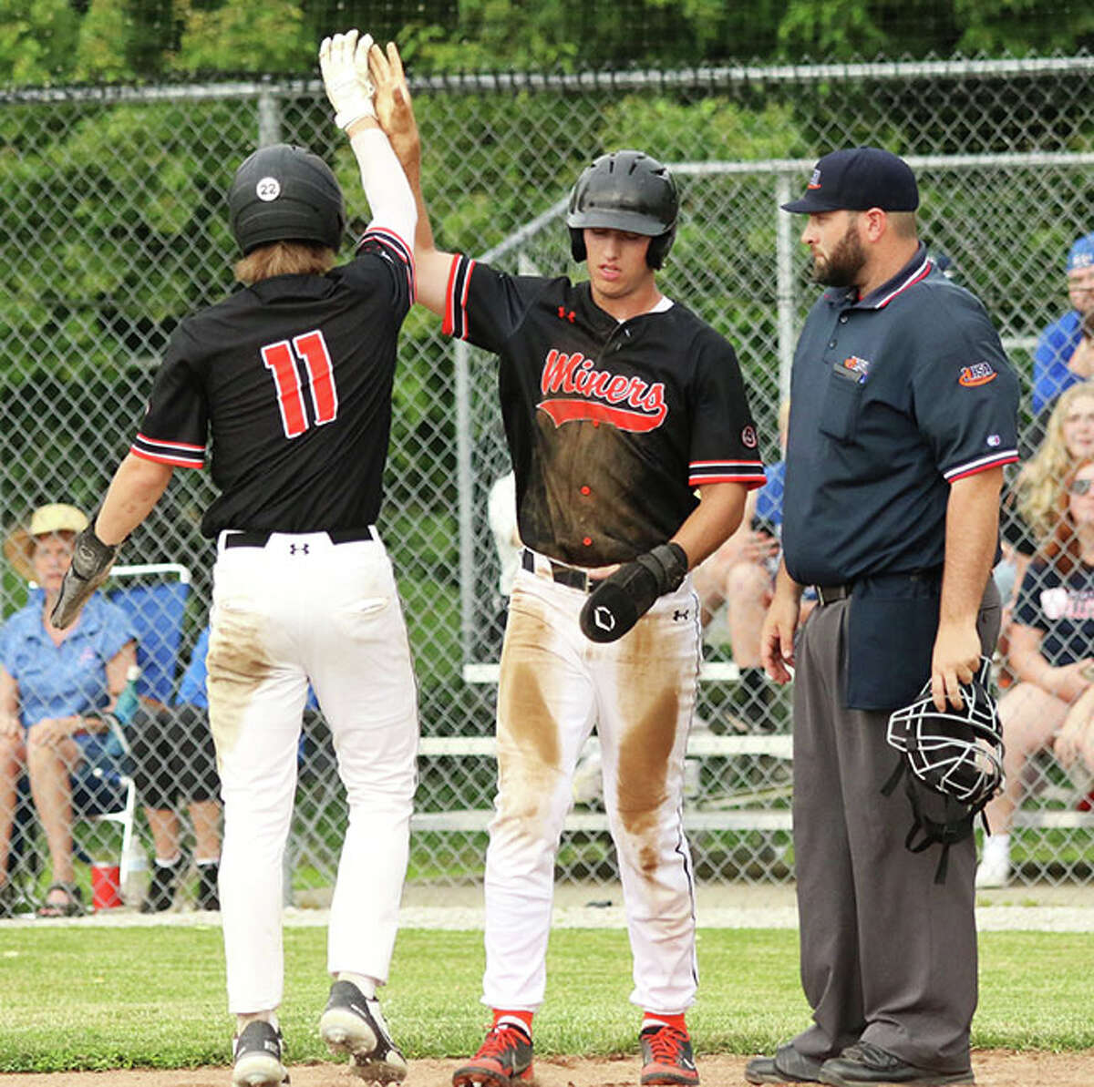 Gillespie's Kamryn Link greets teammate Bryce Buhs (11) after both Miners scored runs in the fourth inning against Carlinville on Thursday in a Class 2A regional semifinal in Gillespie.