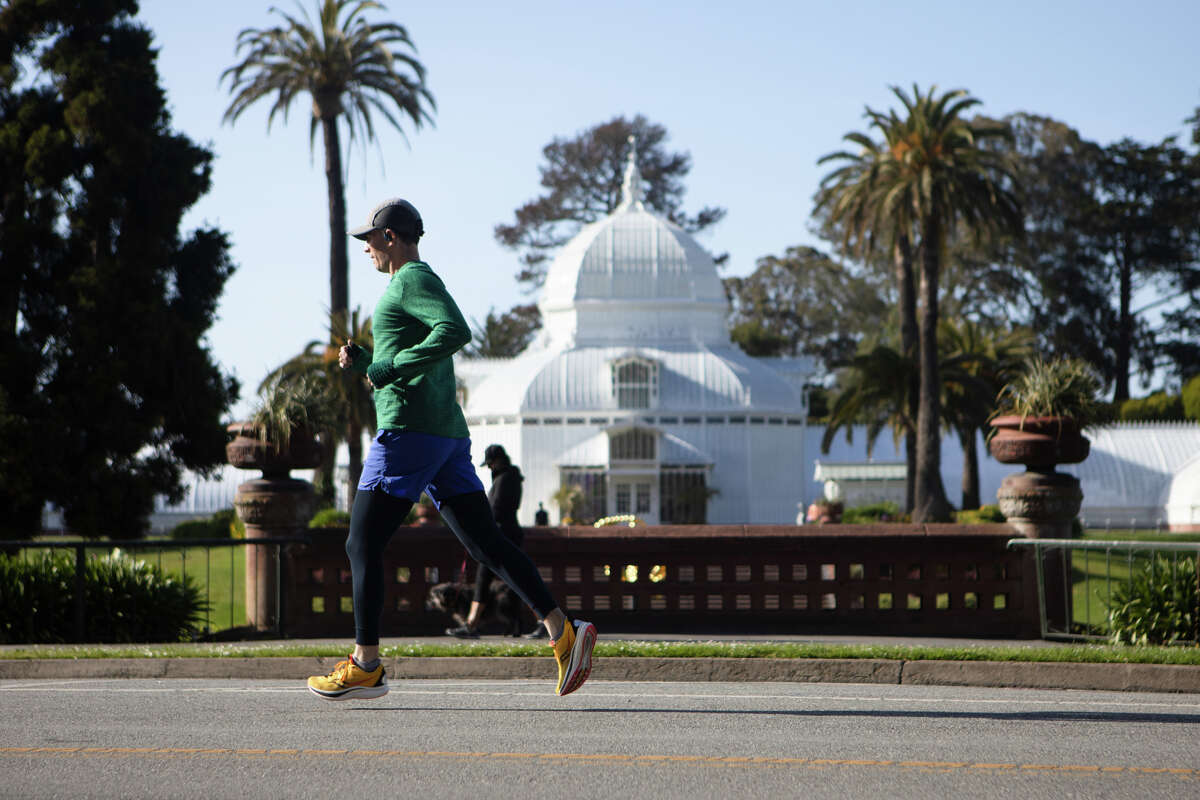 A jogger runs by the Conservatory of Flowers on JFK Drive. Pedestrians, bicyclists and runners used a portion of the 1.5-mile section of JFK Drive that is now permanently free of cars in Golden Gate Park in San Francisco on May 17, 2022.