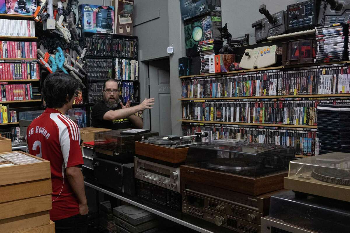 Alejandro “AJ” Martinez Jr., Propaganda Palace business owner, speaks with a customer at Propaganda Palace, May 5, 2022. The owners pride themselves on not only the retro memorabilia, but providing nostalgia itself. (U.S. Air Force photo by Airman 1st Class Andrew Britten)
