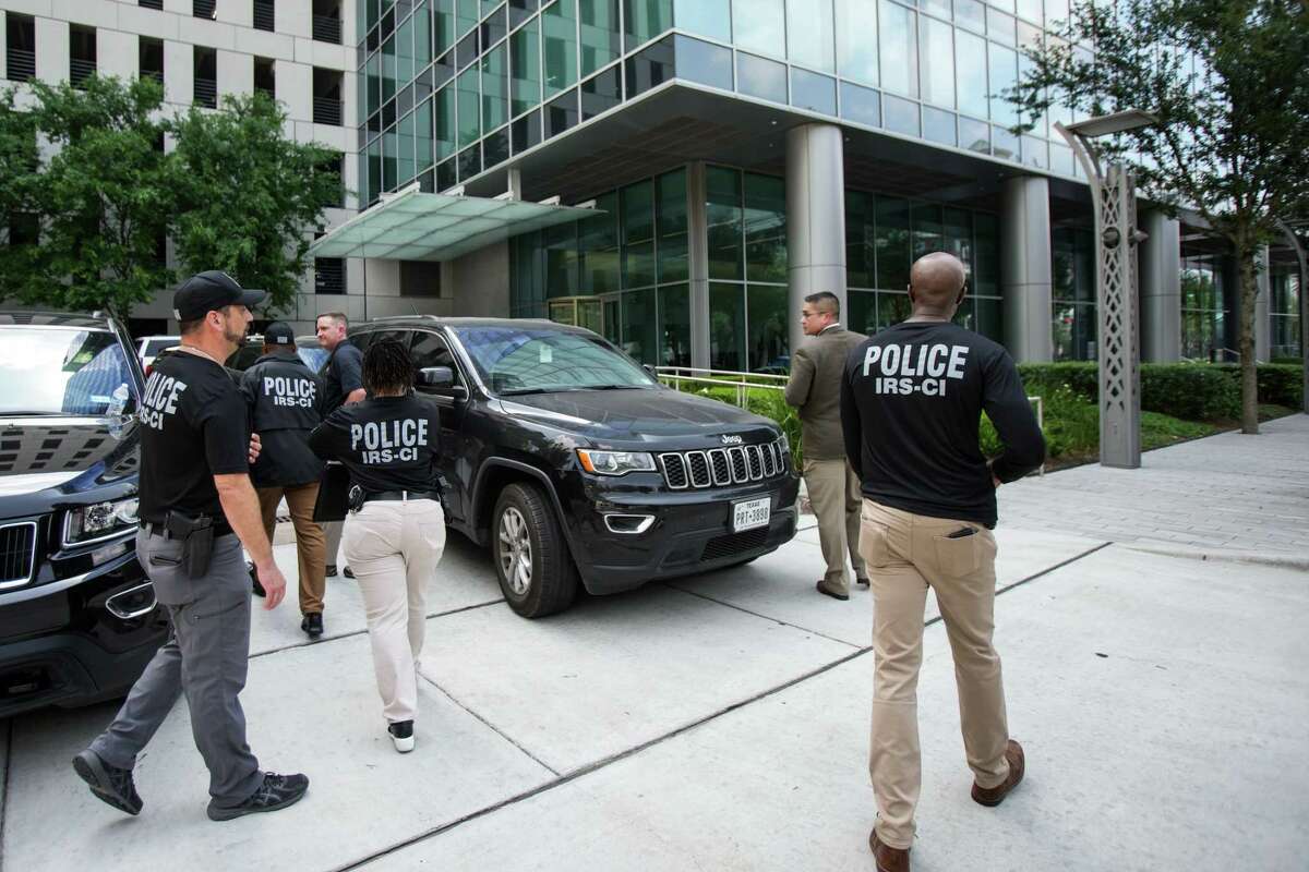 IRS agents walk toward a building in the Galleria area where the agency is conducting a court authorized investigation on a business in the 3900 block of Post Oak Friday, May 20, 2022 in Houston.