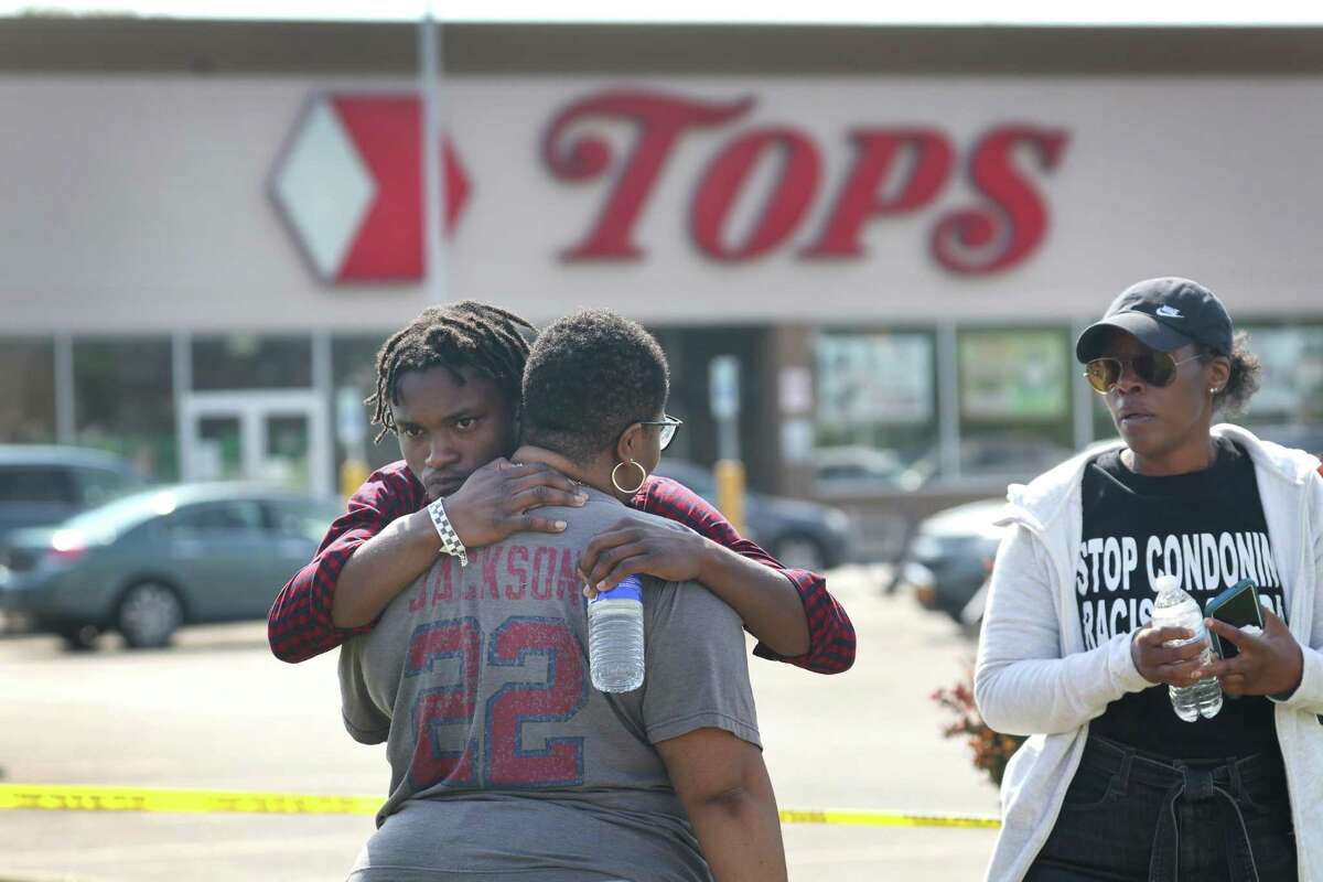 People gathered outside of Tops market embrace following the massacre there. The Republican politicians and conservative media personalities who traffic in the rhetoric of the “great replacement” may not have started the theory, but they have adopted it.