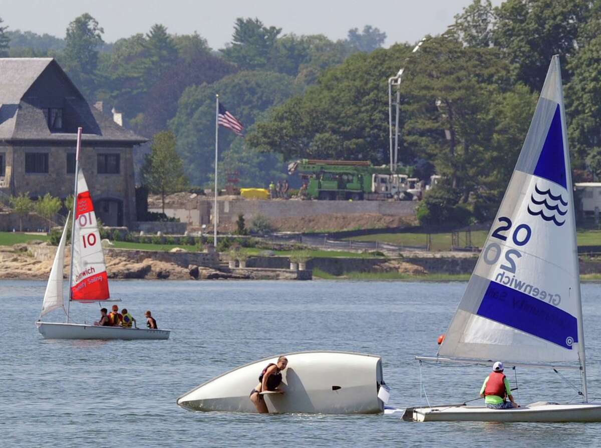 A Greenwich Community Sailing School student, center, practices capsize recovery while taking part in a class off Greenwich Point on July 21, 2015. The new sailing school is slated to open Memorial Day weekend at Greenwich Point.
