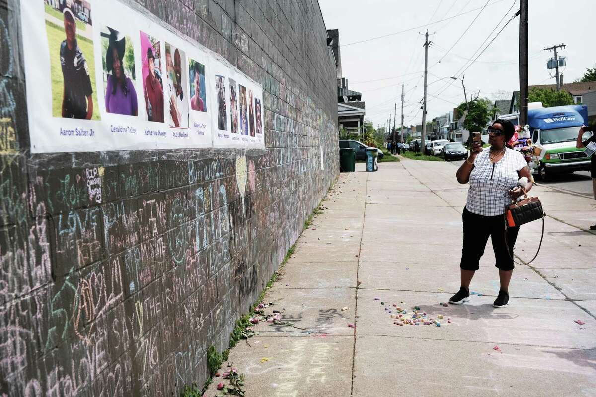 BUFFALO, NEW YORK - MAY 20: A person observes a memorial for the shooting victims outside of Tops grocery store on May 20, 2022 in Buffalo, New York. 18-year-old Payton Gendron is accused of the mass shooting that killed 10 people at the Tops grocery store on the east side of Buffalo on May 14th and is being investigated as a hate crime. (Photo by Spencer Platt/Getty Images)