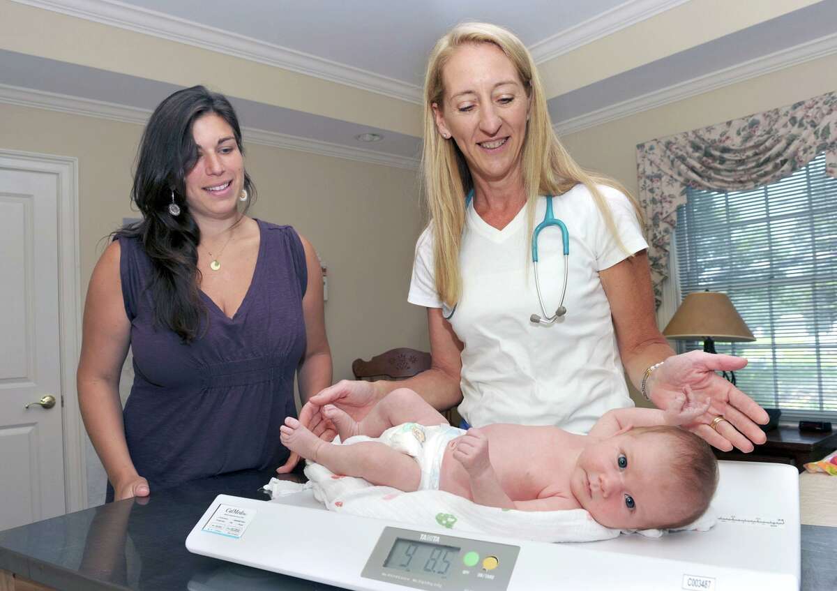 Catherine Parisi, right, weighs a one-month-old at The Connecticut Childbirth and Women’s Center in Danbury, Conn., in 2011.