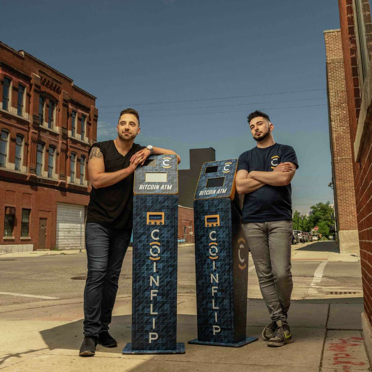 Two executives, Daniel Polotsky and Ben Weiss, from crypto-ATM company CoinFlip pose next to their company's machines.