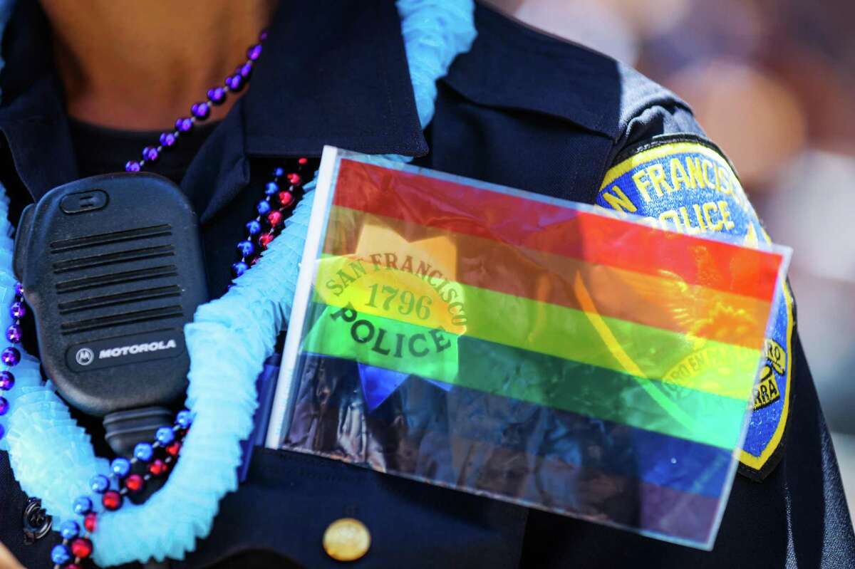在2016年旧金山同志大游行中，Christine Magazines警官在胸针上戴着一面旗帜。