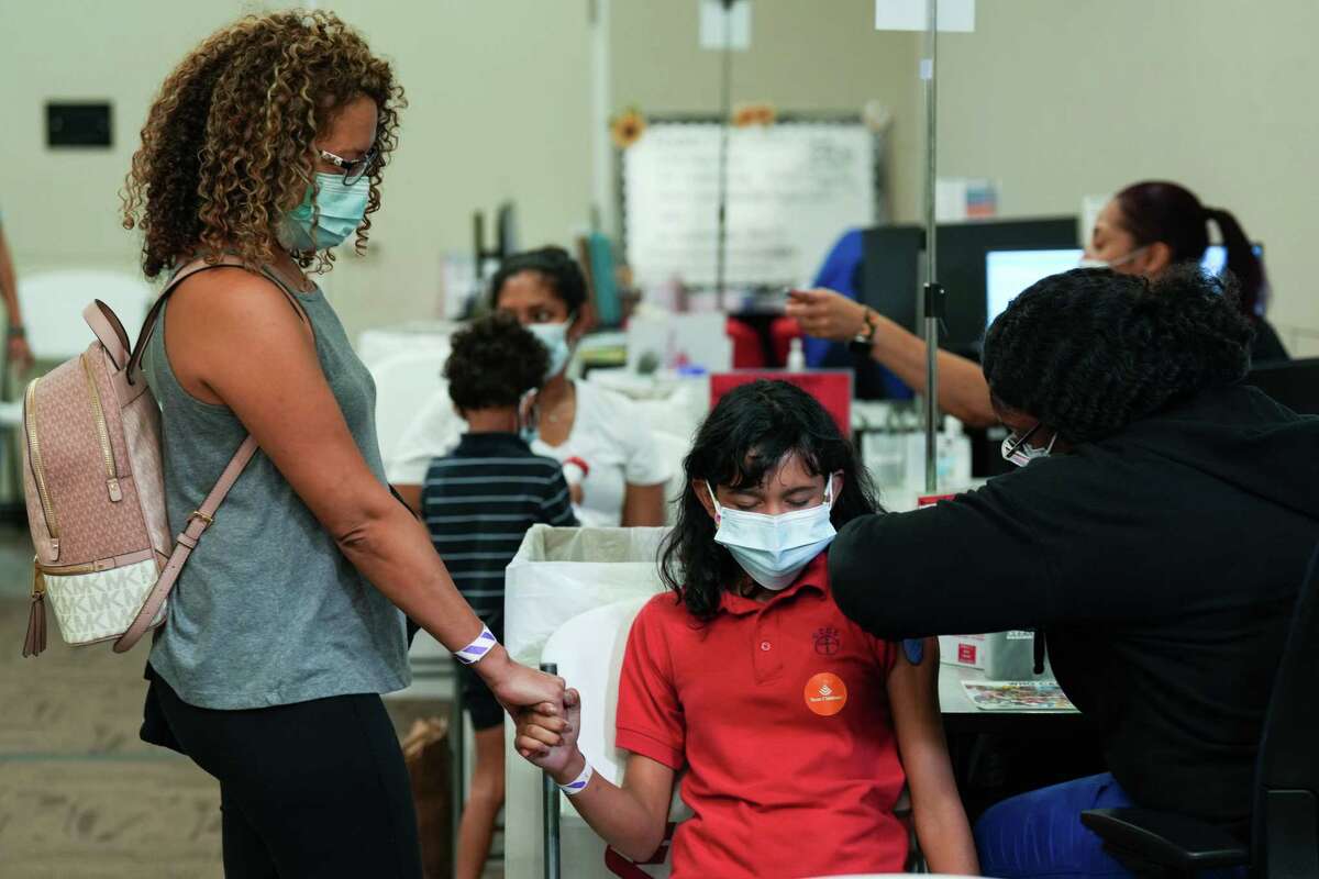 Alicia LaBarrie, left, holds her daughter, Gabrielle’s hand, as the 10-year-old receives a Pfizer-BioNTech COVID-19 booster vaccine from Brittanee Modiseete, LVN, during a vaccination clinic at Texas Children’s Hospital Friday, May 20, 2022 in Houston. Texas Children’s and all TCH Pediatrics practices began administering the Pfizer-BioNTech COVID-19 vaccine booster Friday to children aged 5 to 11, following FDA Emergency-Use Authorization.