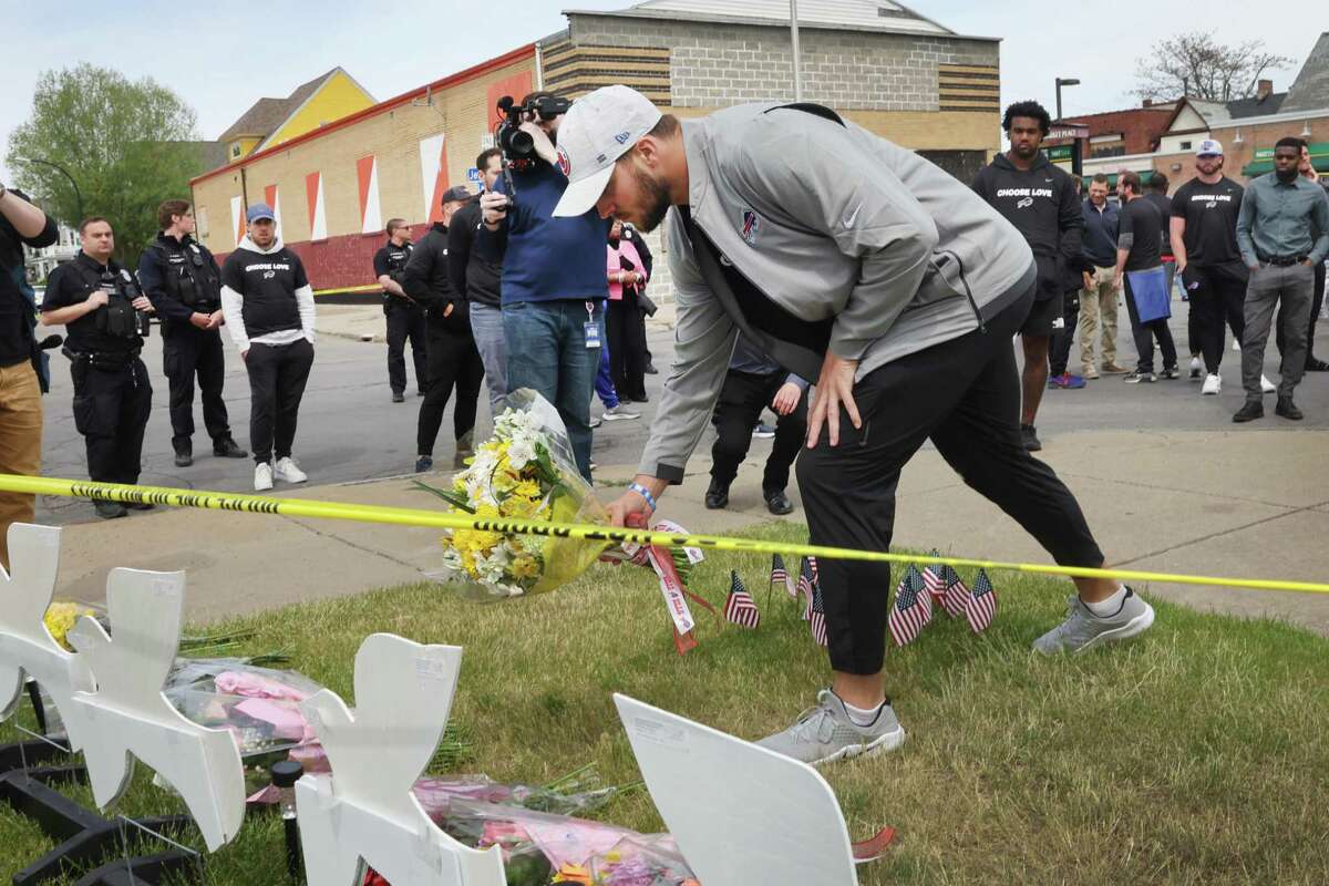Buffalo Bills quarterback Josh Allen lays flowers May 18 on a memorial near the Tops Friendly Market where 10 people were killed earlier in the day in Buffalo, N.Y.