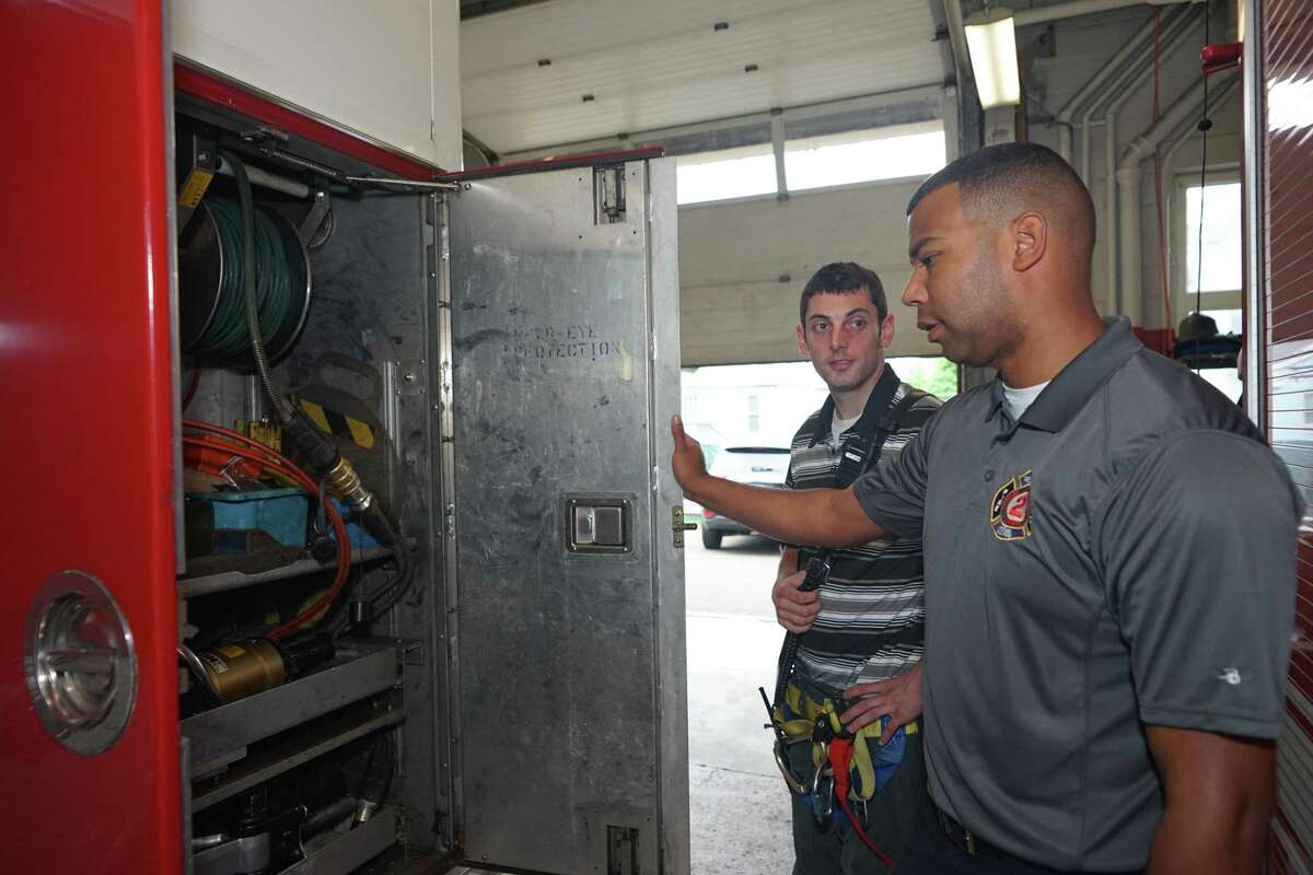 Storm Ambulance Corps. Chief Javonte Ramos inspects one of the fire trucks parked at the ambulance corps.’ location alongside Fire Department Captain Alex Neuendorf in Derby on May 20.