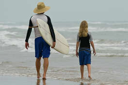 Father and daughter going surfing in South Texas.