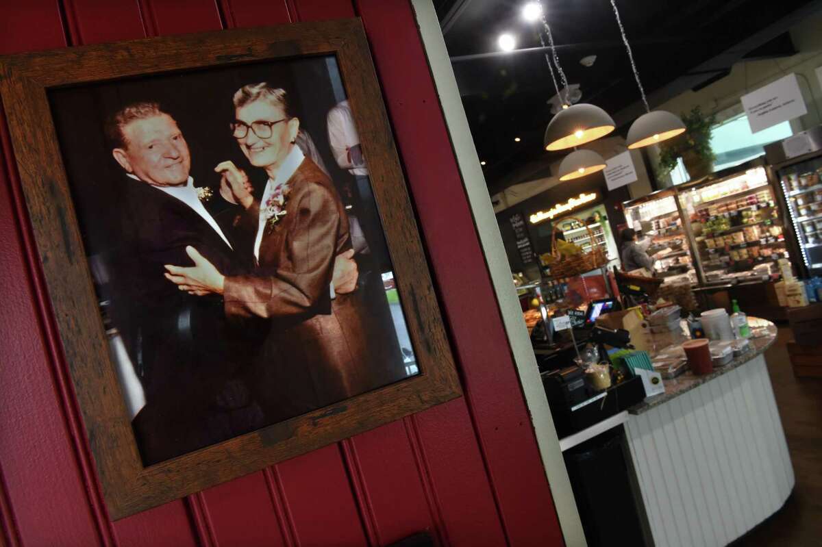 A photograph of Anastasia “Gina” DiNatale and her husband hang at the entrance to Nonna Gina’s Prepared Foods and Gelateria in Branford on May 19, 2022.