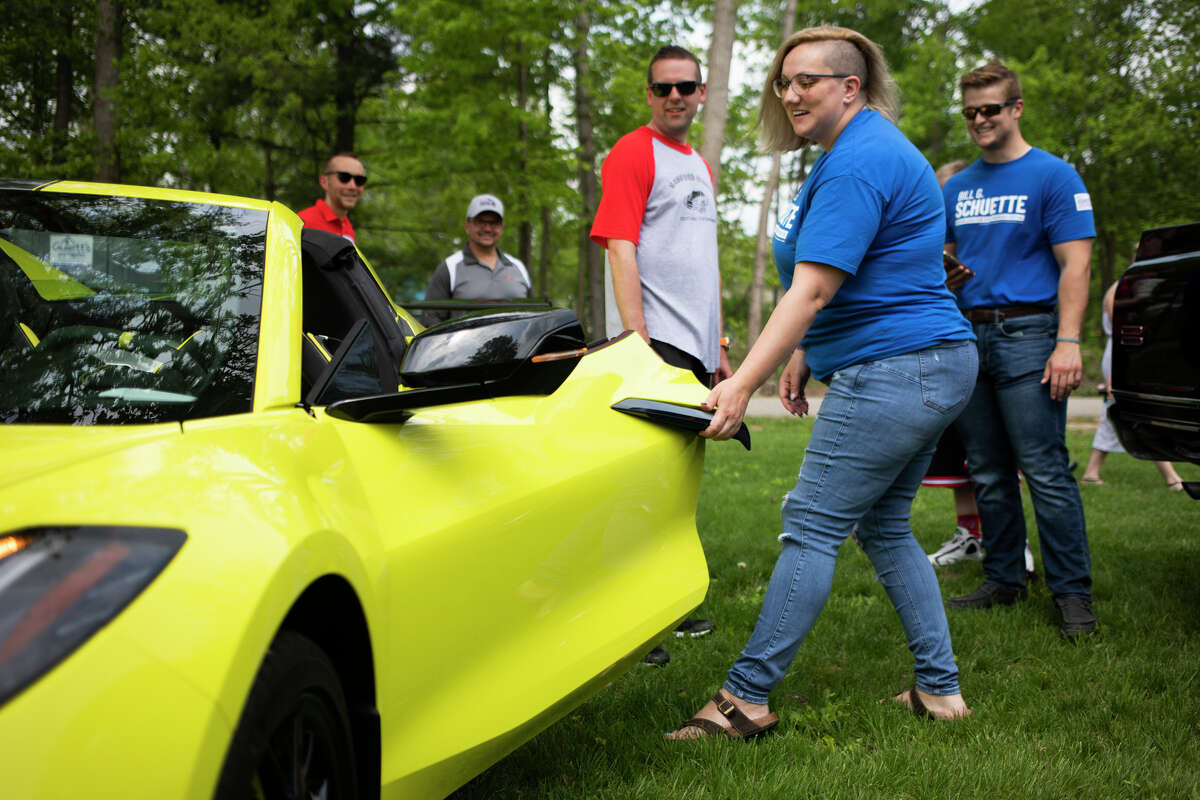 Amanda Oster checks out a sports car during the Sanford Rising Car Show on Friday May 20, 2022 at Porte Park.