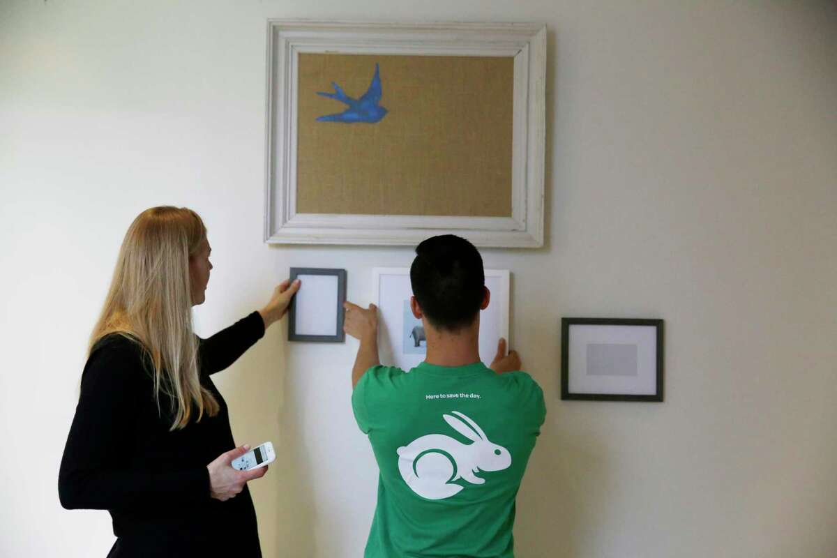 Thai-can "Paul" Nguyen (right), Taskrabbit tasker, consults with Lauren Fraser (left) in her San Francisco home. The company, which is headquareted in the city, has announced it will close all office spaces become a remote work operation.