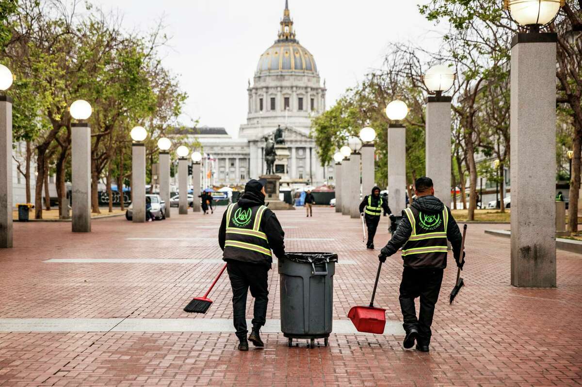 Members of the Urban Alchemy team conduct a morning sweep at United Nations Plaza in San Francisco.