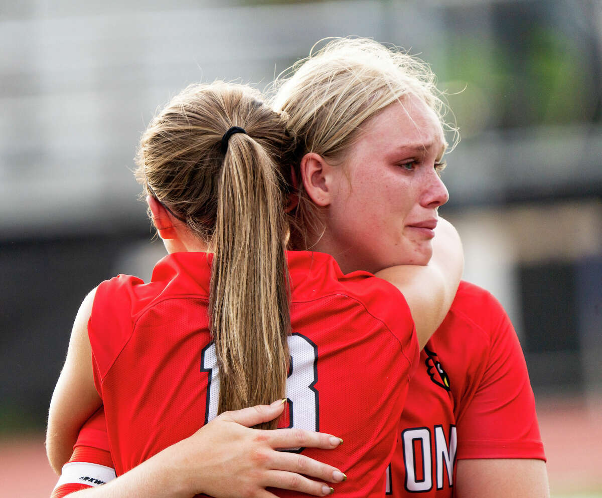 Alton senior Taylor Freer (24) is consoled by teammate Alayna Rabozzi (13) Friday following the Redbirds' 2-1 Collinsville 3A Regional Tournament final loss to Edwardsville at Kahok Stadium.