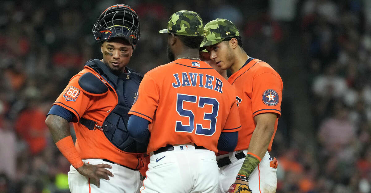 Houston Astros catcher Martin Maldonado (15) chats with starting pitcher Cristian Javier (53) and shortstop Jeremy Pena (3) after Javier walked Texas Rangers Marcus Semien during the sixth inning of an MLB game at Minute Maid Park on Friday, May 20, 2022 in Houston.