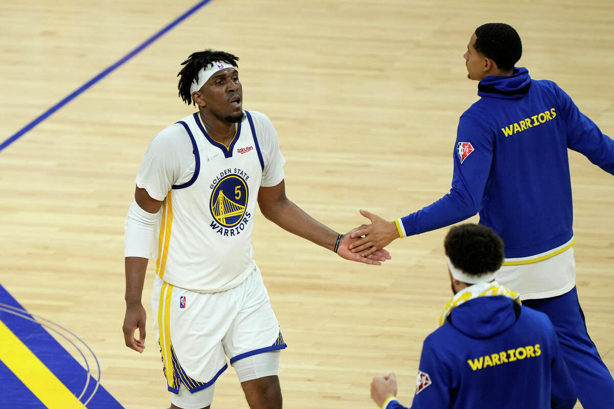 Kevon Looney, left, of the Golden State Warriors celebrates a dunk with teammates at the end of the third quarter against the Dallas Mavericks in Game 2 of the 2022 NBA Playoffs Western Conference Finals at Chase Center on May 20, 2022, in San Francisco. 
