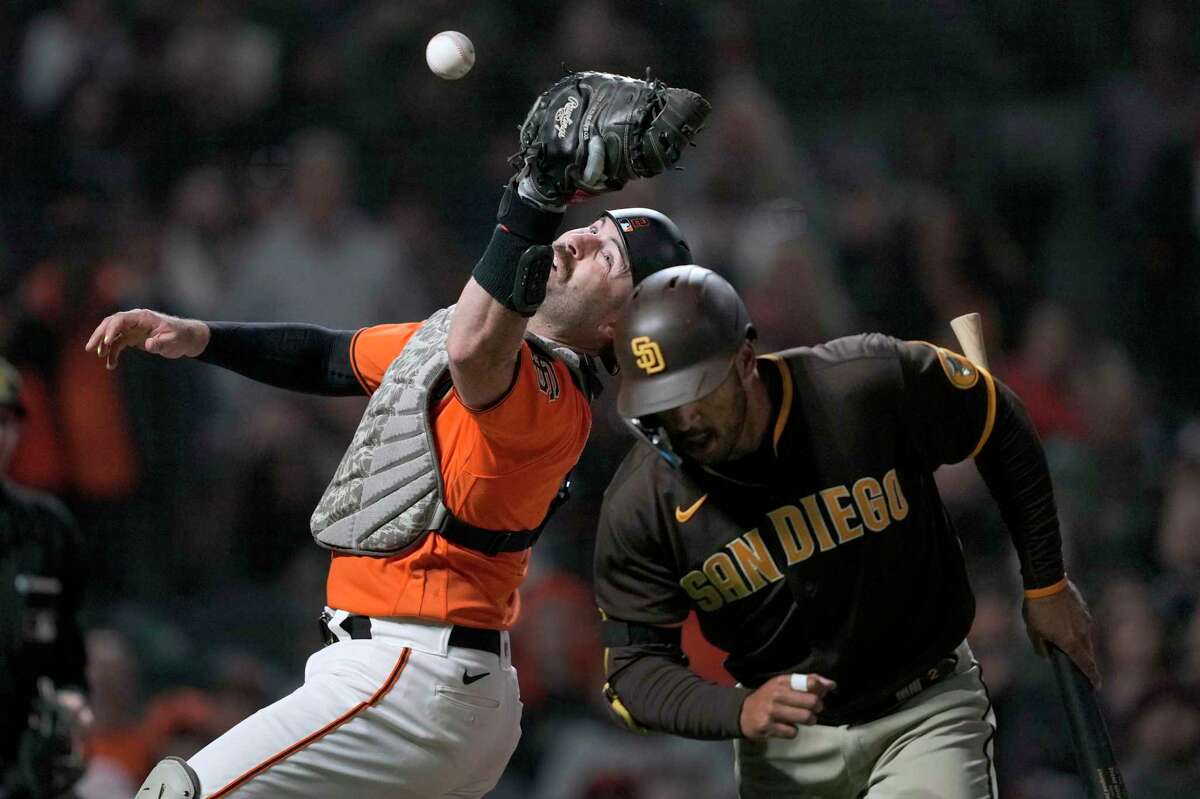 San Francisco Giants catcher Curt Casali drops a foul ball next to San Diego Padres' Trent Grisham during the seventh inning of a baseball game in San Francisco, Friday, May 20, 2022. (AP Photo/Tony Avelar)